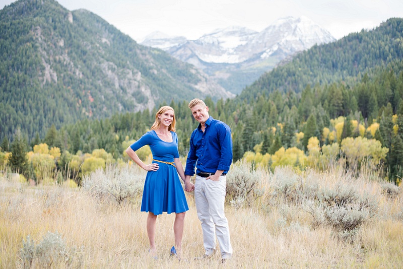 Vivid outdoor couple photography with mountain backdrop, colorful fall foliage, and natural landscape, captured by Meghan Rose Photography for romantic engagement or lifestyle sessions.
